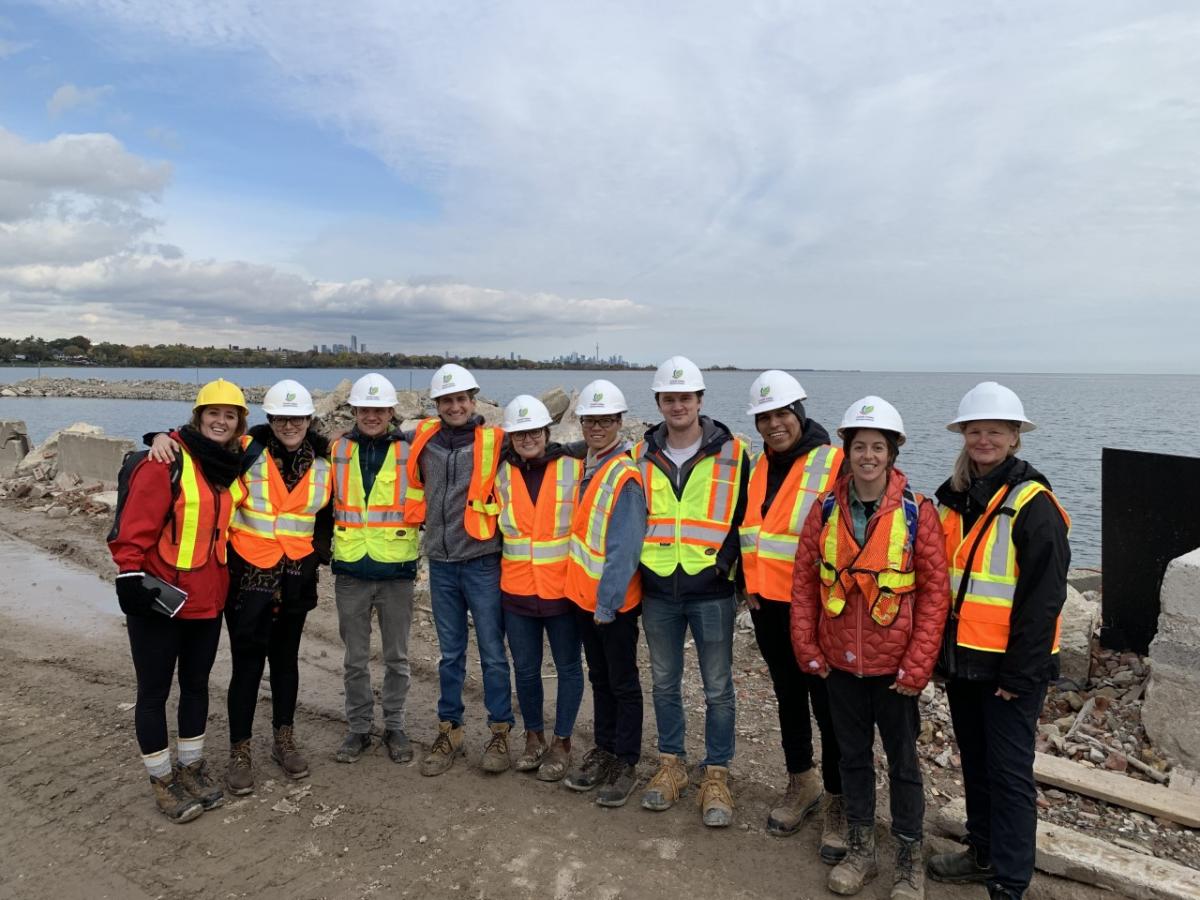 Students with hard hats standing in front of Lake Ontario shoreline