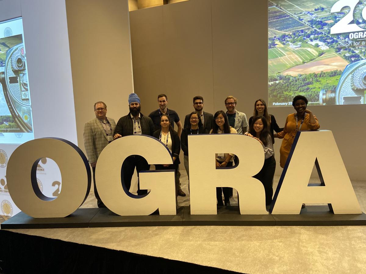 Students standing behind large OGRA letters