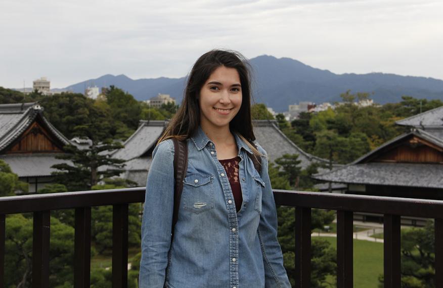 Girl on balcony overlooking houses and mountains