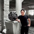 Colin Okashimo standing next to sculpture