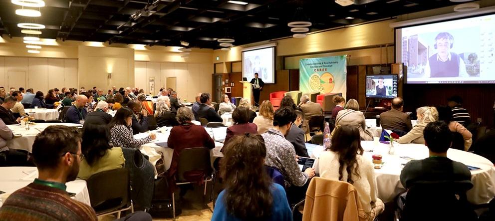 People sitting at tables listening to guest speaker at CAREE Conference