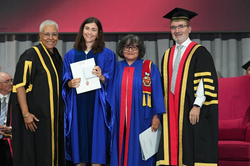 Four people standing together at convocation ceremony