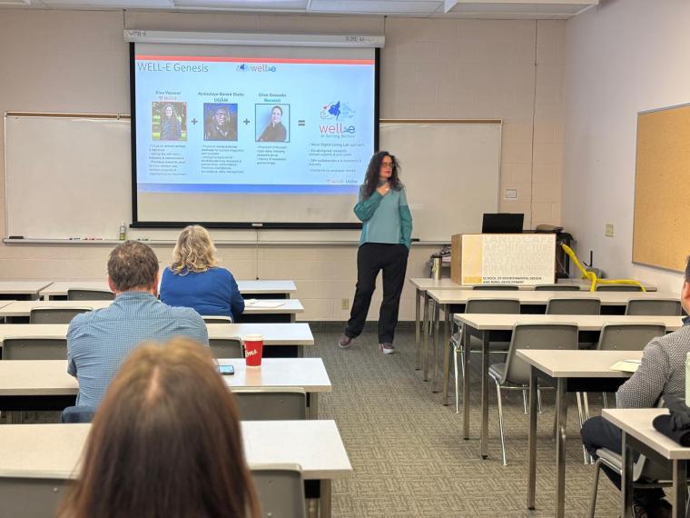 Dr. Vasseur presenting her talk on a screen to a seated crowd.