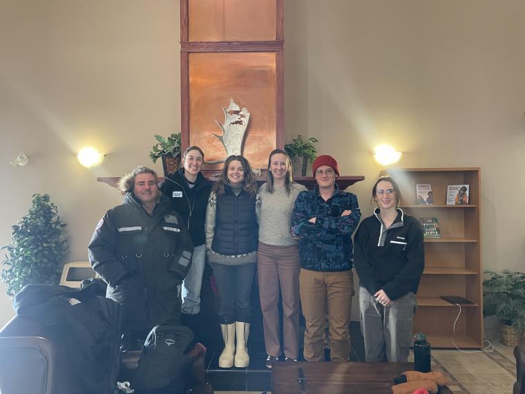 Six researchers standing together in front of fire place