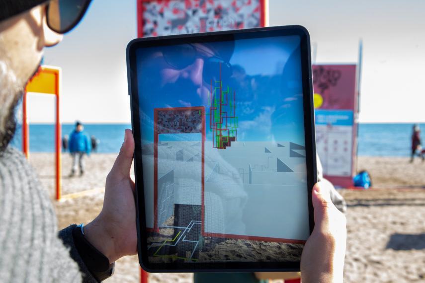 A man holding a tablet to view interactive augmented reality exhibit