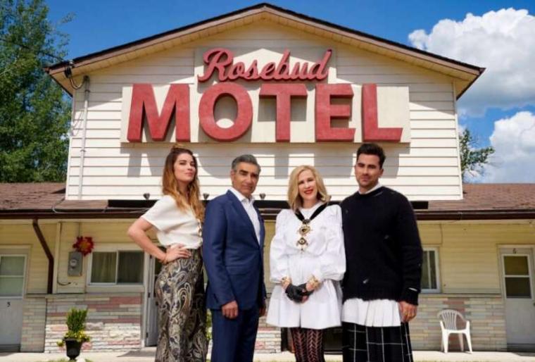 Four people standing outside in front of motel