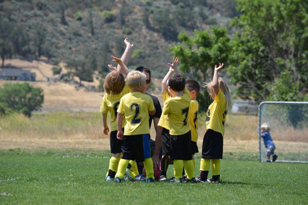 Children's soccer team together listening to coach