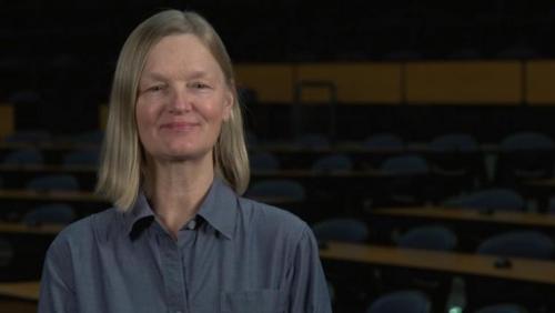 Karen Landman sitting in front of a classroom