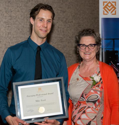 Mike Teed holding award, standing beside Carol Craig