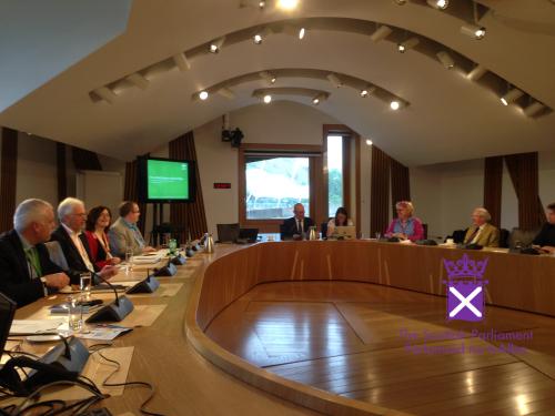 People sitting around oval table presenting to the Scottish Parliamentary Cross Party Committee on Rural Policy