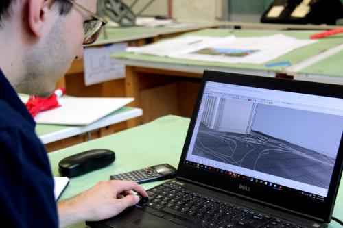 Michal Laszczuk at desk viewing 3-D model on computer