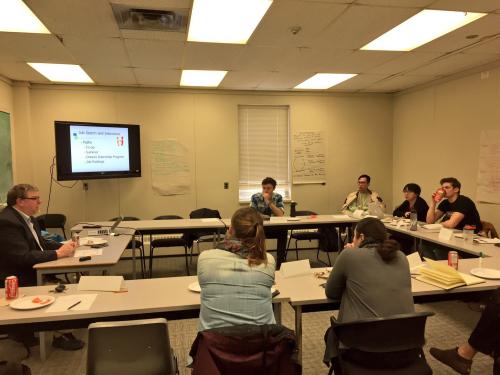 Students sitting around a table discussing workshop