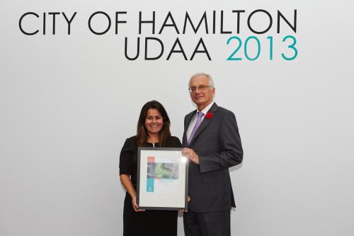 Leila Todd holding award and standing beside the Mayor of the City of Hamilton