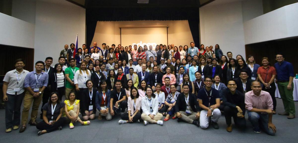 Group photo of ADCEP conference participants standing and sitting