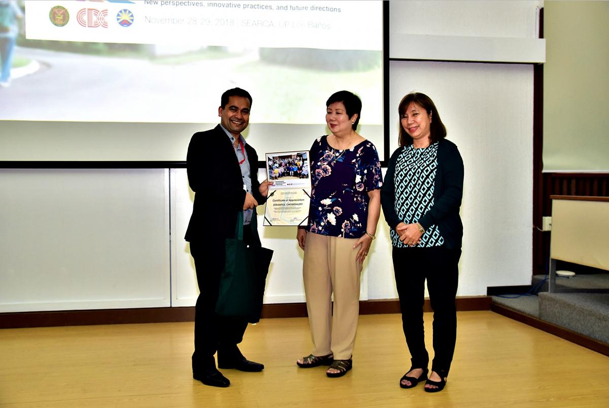 Dr. Chowdhury receiving certificate from two individuals