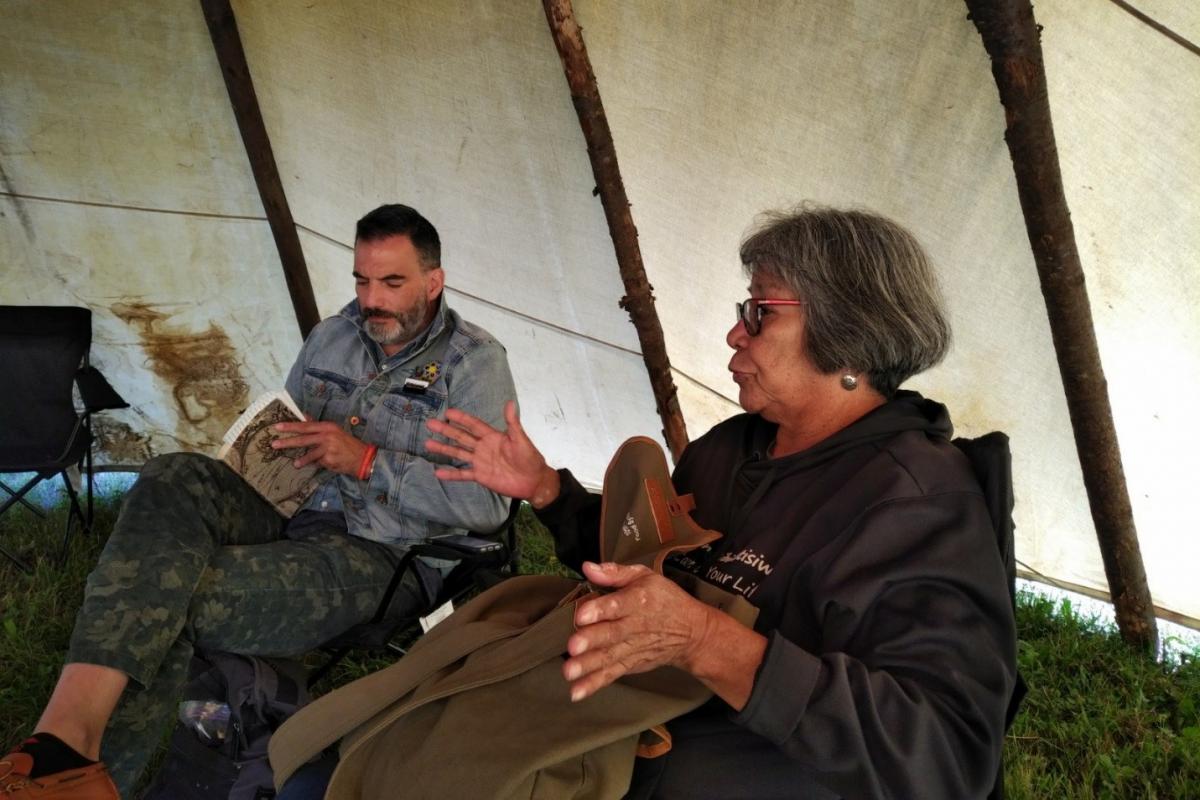 Two people gathering stories in tipi