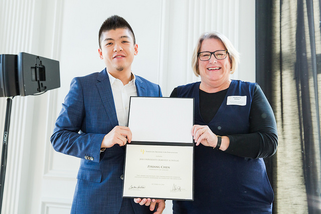 Student and presenter holding up award parchment