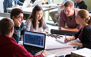 Five students working discussing project in studio