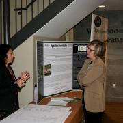 Pam Duesling (left) sharing information on her research with participant at table booth