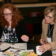 Katie Allen sharing information with another participant at table
