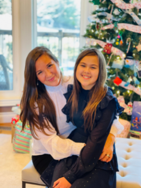 Picture of Charity Fleming and her daughter in front of a christmas tree. 